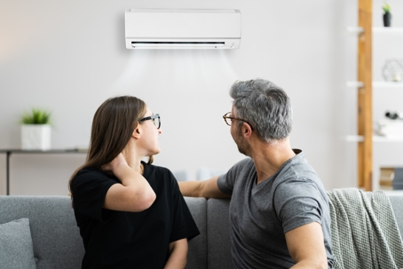 Couple looking at a noisy and problematic AC.